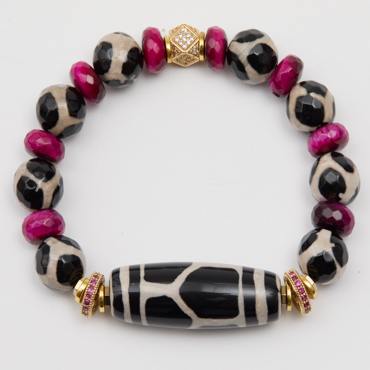 Bracelet with black and white patterned beads and pink accents on a white background