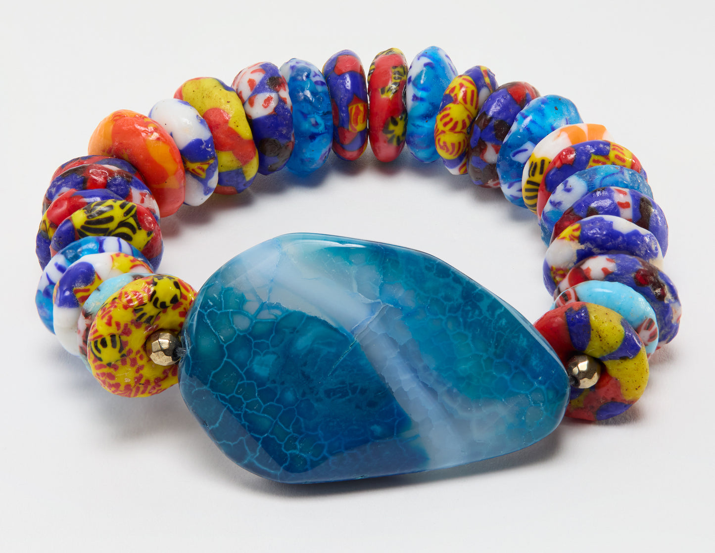 Colorful beaded bracelet with a large blue stone on a white background