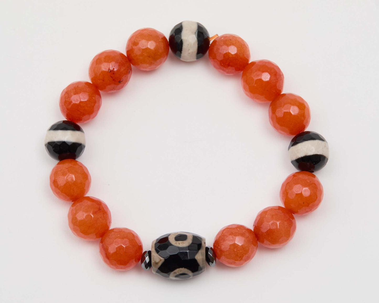 Bracelet with orange and black beads on a white background