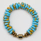 Turquoise beaded bracelet with gold accents on a white background