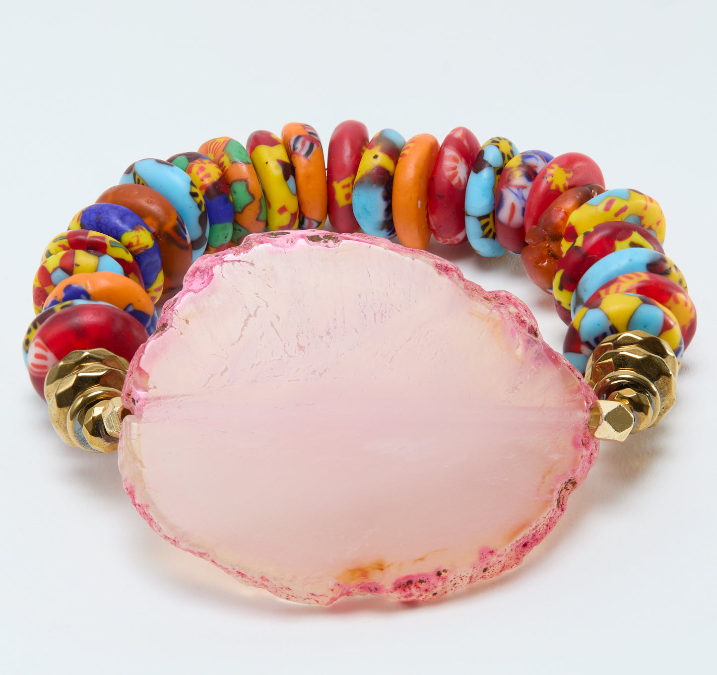 Colorful beaded bracelet with a pink central stone on a white background