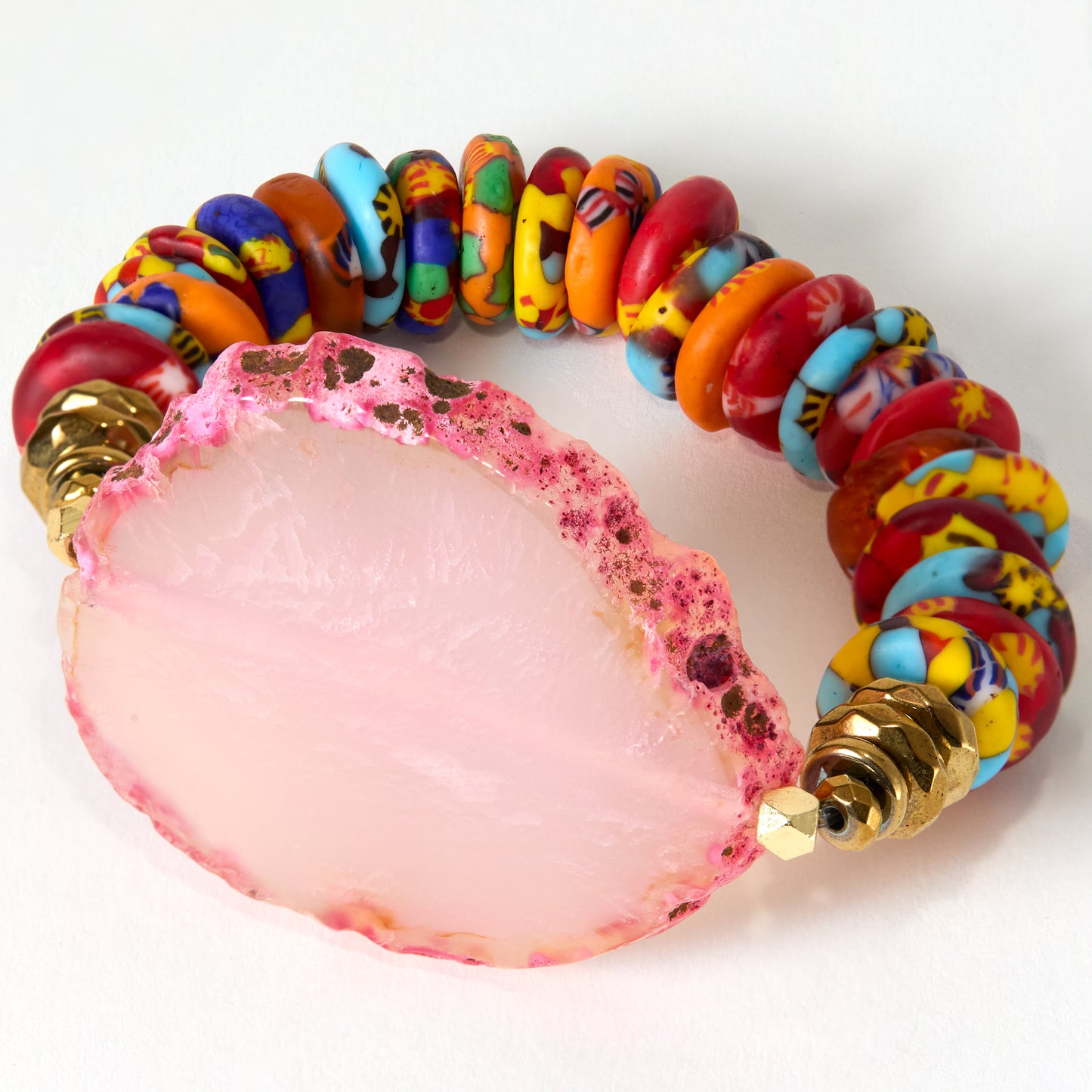 Colorful beaded bracelet with a pink stone on a white background