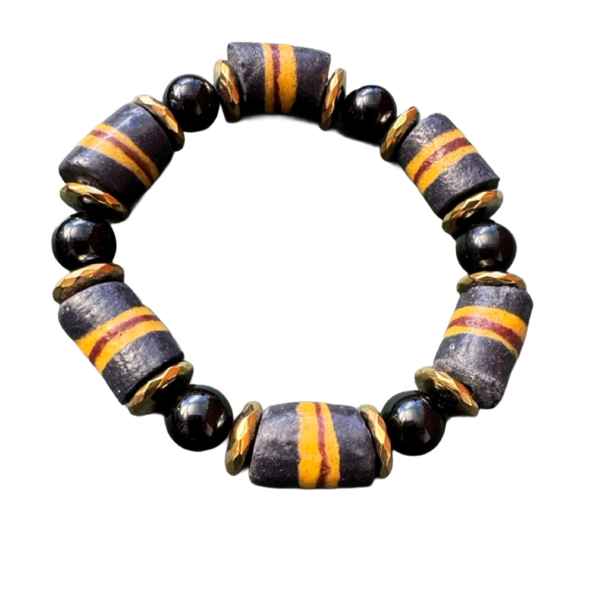 A beaded stretch bracelet featuring alternating matte black round beads and textured cylindrical beads with a dark gray/black base and orange-yellow stripes, separated by small gold spacers, on a plain white background.
