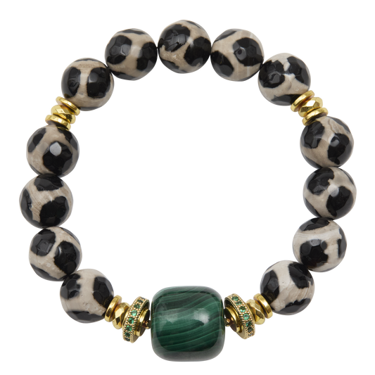Bracelet with black and white patterned beads and a green gemstone on a white background