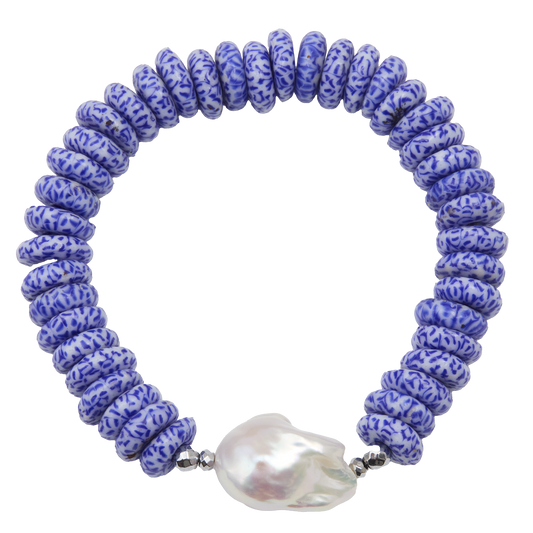 Blue beaded bracelet with a large white pearl on a white background