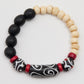 Bracelet with black, white, and red beads on a light gray background