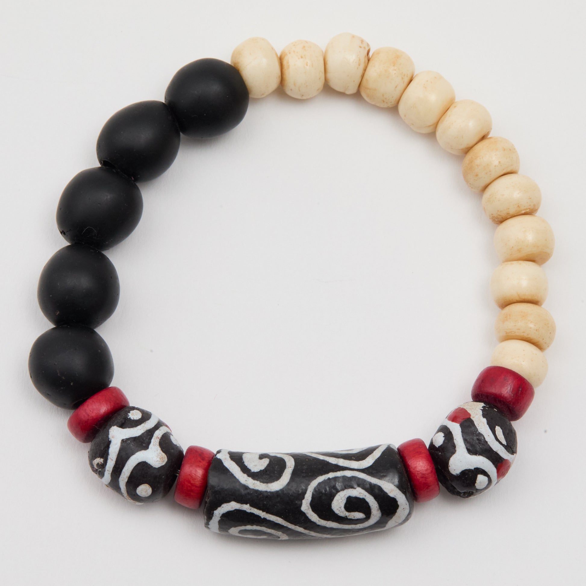 Bracelet with black, white, and red beads on a light gray background
