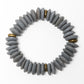 A circular beaded bracelet made of grey Ashanti beads with brass spacer beads, shown on a plain white background.
