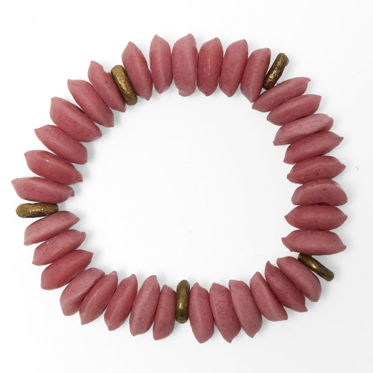 A beaded stretch bracelet made of dusty rose pink Ashanti beads with brass accent beads, displayed on a clean white background.