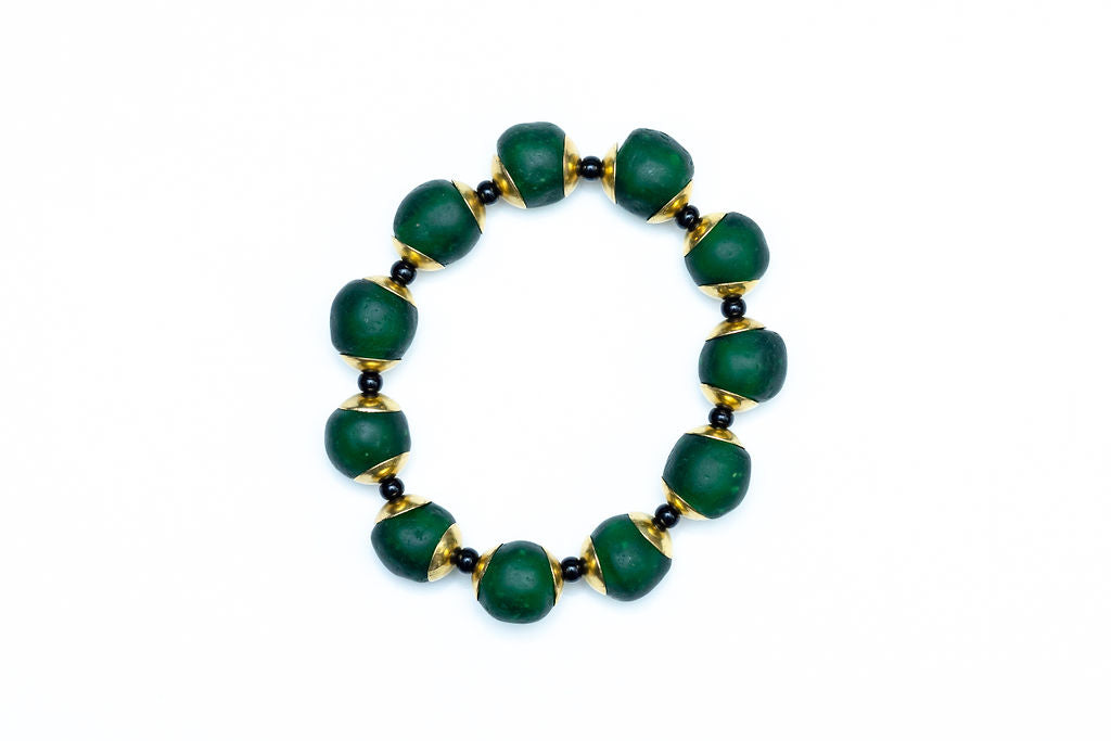 Hunter green bracelet with brass and black accent beads against white background