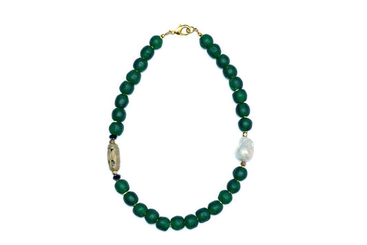 A hunter green beaded necklace with a brass focal bead and a baroque pearl, featuring hematite spacers and lampwork glass beads.