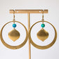 Gold hoop earrings with turquoise beads on a gold stand against a white background