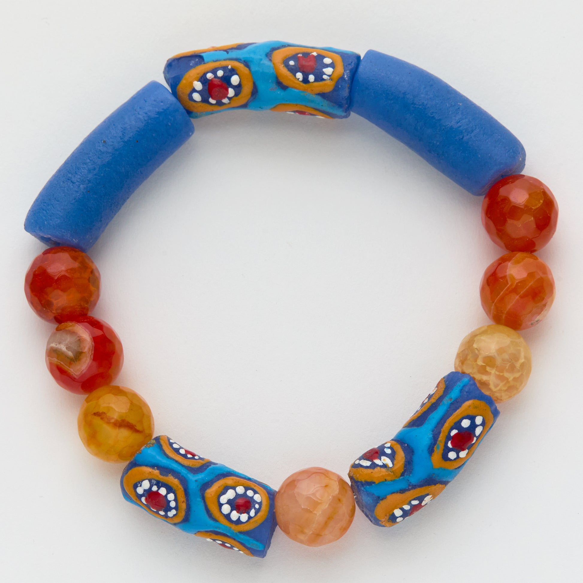 Colorful beaded bracelet with blue cylindrical beads and patterned orange beads on a white background