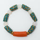 Bracelet with patterned beads and a central orange bead on a white background