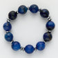 Blue beaded bracelet with silver accents on a white background