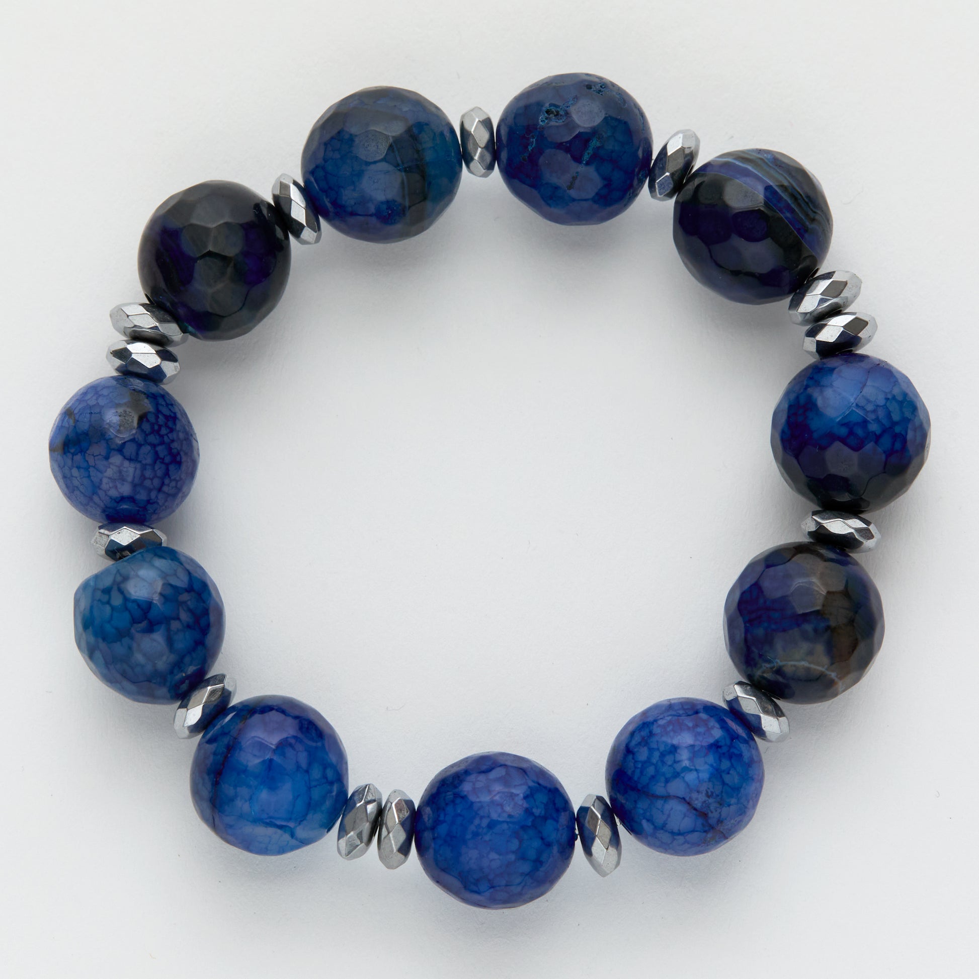Blue beaded bracelet with silver accents on a white background