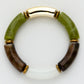 Bracelet with green, brown, and gold elements on a white background