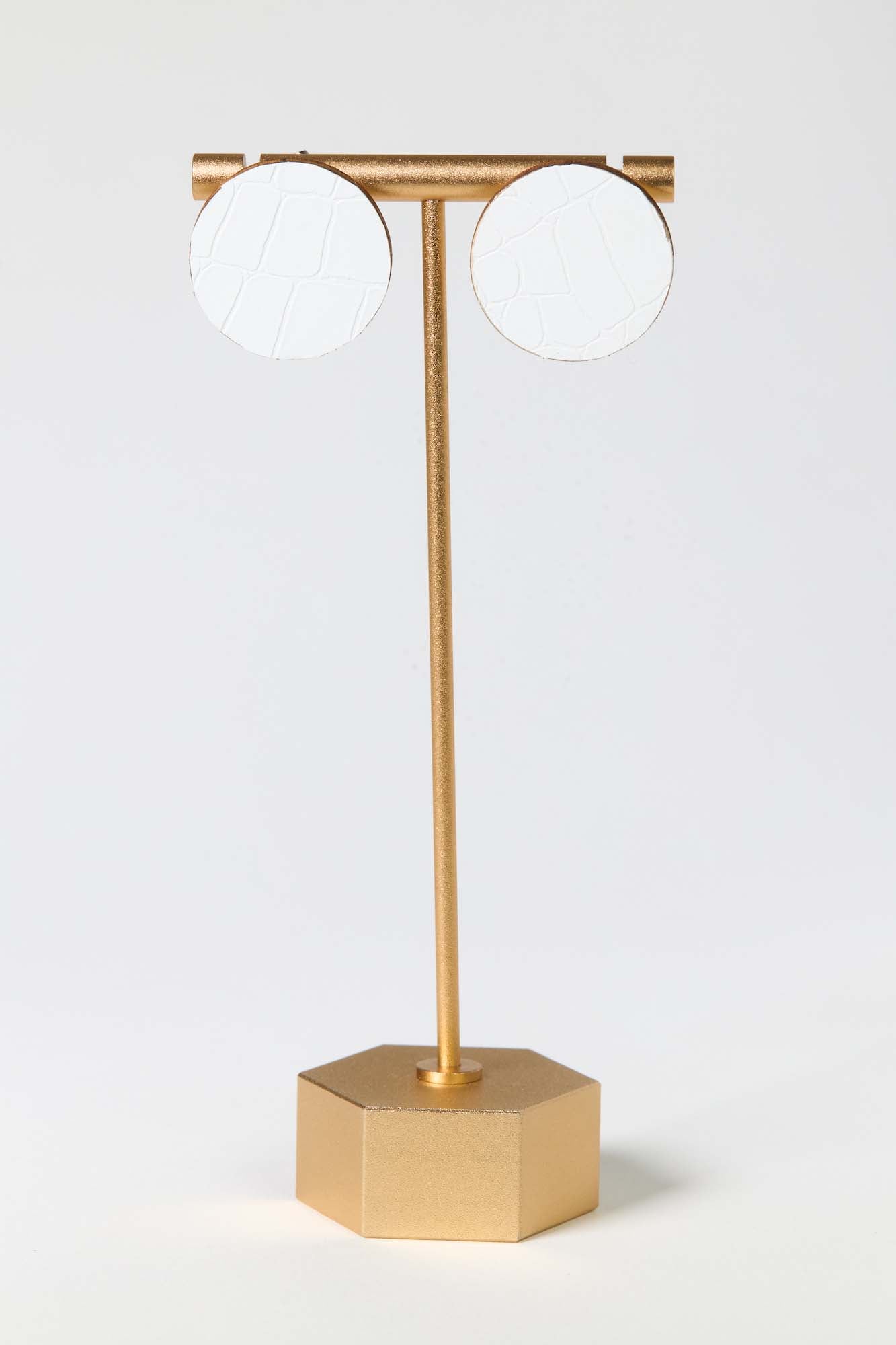 Gold lamp with two round white lights on a light gray background