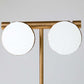 Modern ceiling light fixture with two round white lights on a gold frame against a gray background