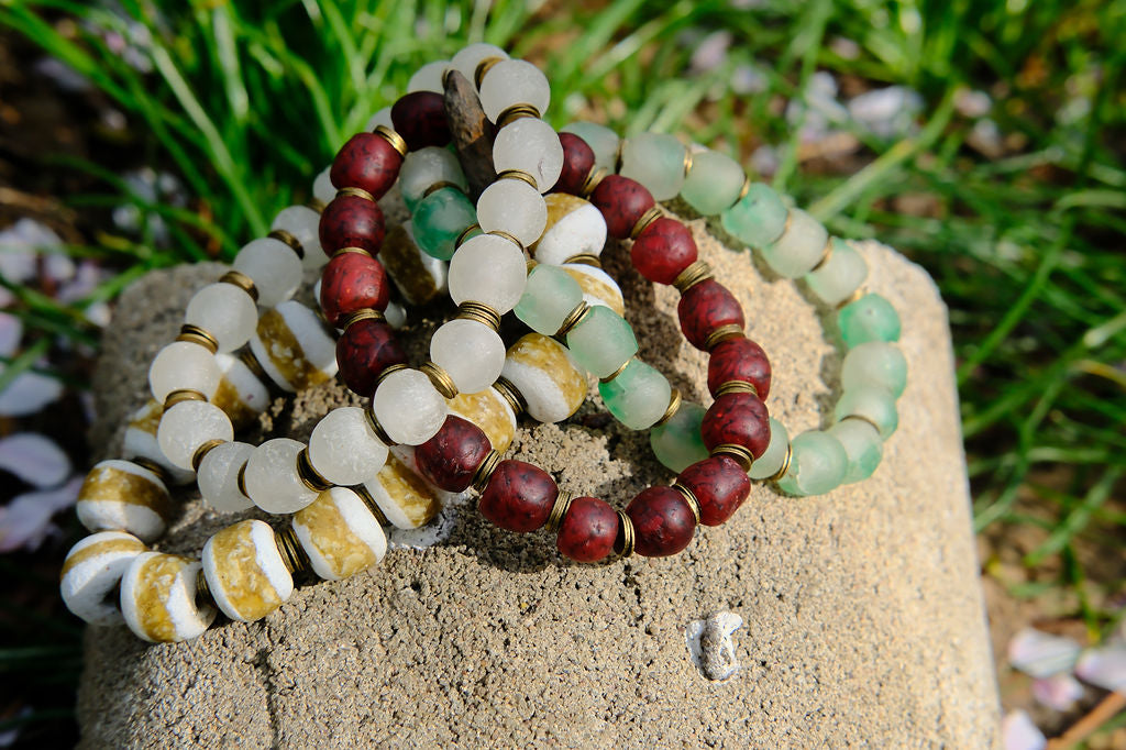 Set of beaded bracelets on a stone with grass in the background