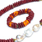 A Cicely necklace featuring a combination of burgundy Ashanti beads and freshwater baroque pearls, with brass accents and gold-plated lobster clasp, with coordinating bracelet, against white background.