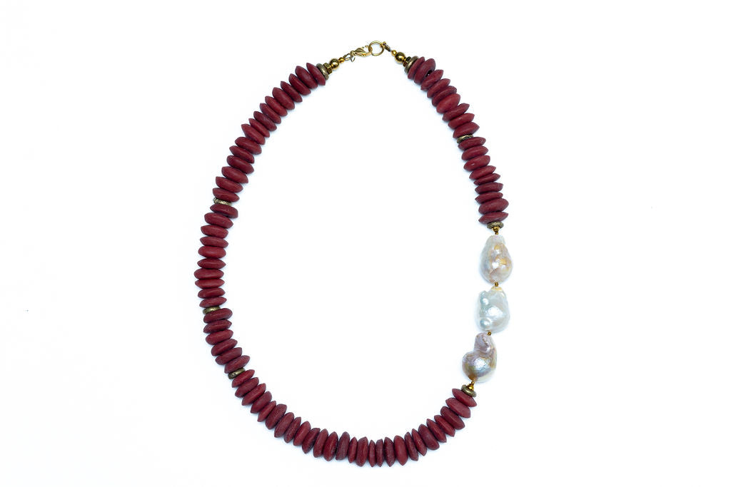 A 20 inch Cicely necklace featuring a combination of burgundy Ashanti beads and freshwater baroque pearls, with brass accents and gold-plated lobster clasp against white background.