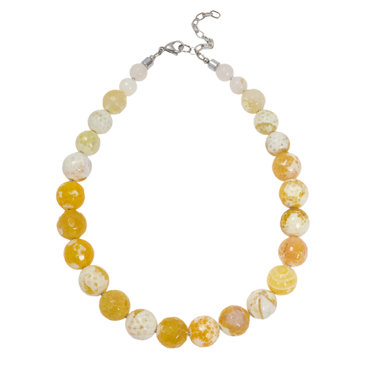 Necklace with yellow and white marbled beads on a white background