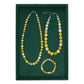 Set of beaded necklace and bracelet on a green background