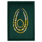 Set of beaded necklaces and bracelet on a green background