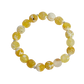 Yellow and white marbled bead bracelet on a white background