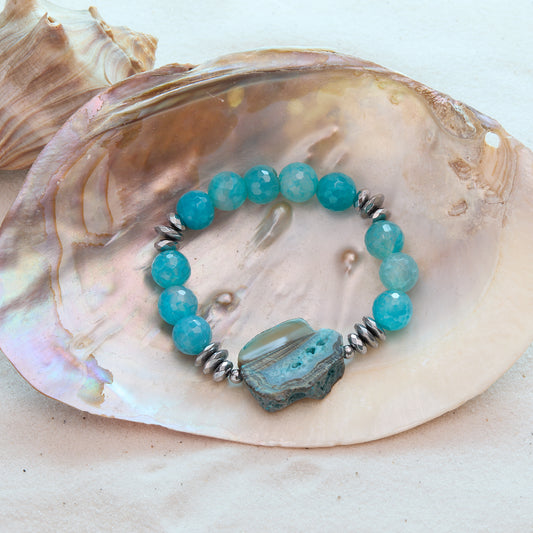 Turquoise beaded bracelet with a large blue stone on a seashell