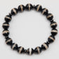Black and beige beaded bracelet on a white background