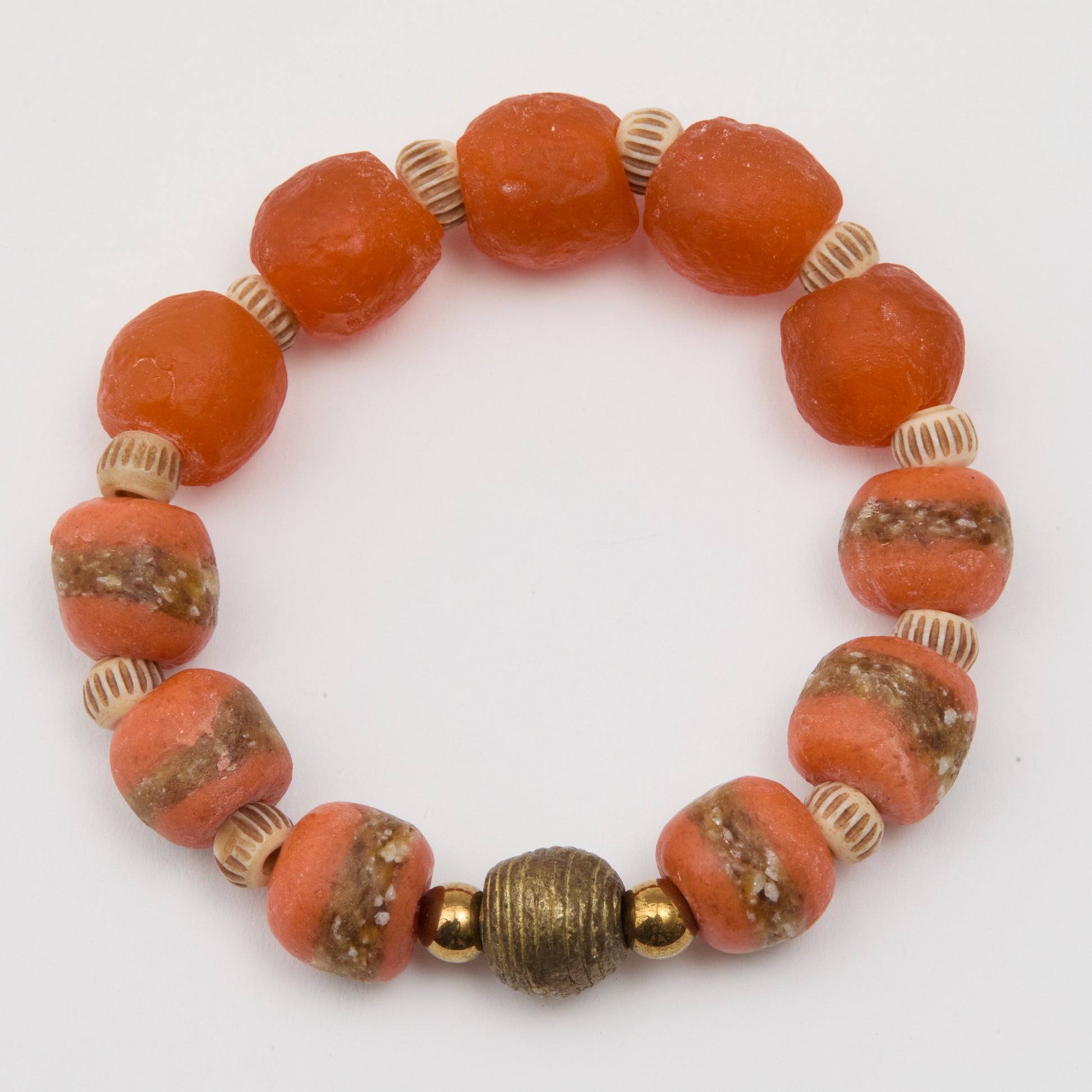 Bracelet with orange beads and gold accents on a white background
