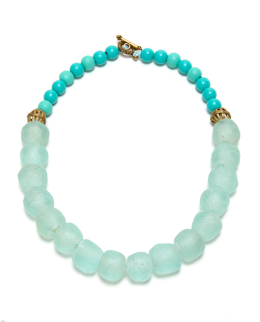 Turquoise and gold beaded necklace on a white background