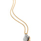 Necklace with a gold chain and a large, rough-cut gemstone pendant on a white background