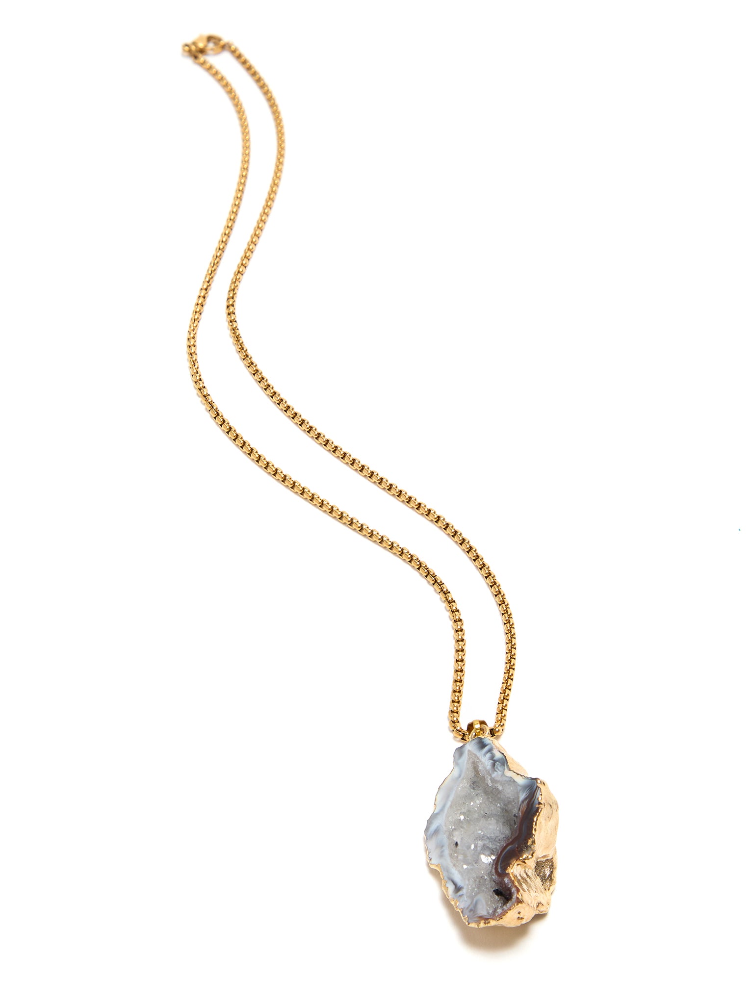Necklace with a gold chain and a large, rough-cut gemstone pendant on a white background