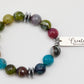 Multicolored beaded bracelet with a silver tag on a white background