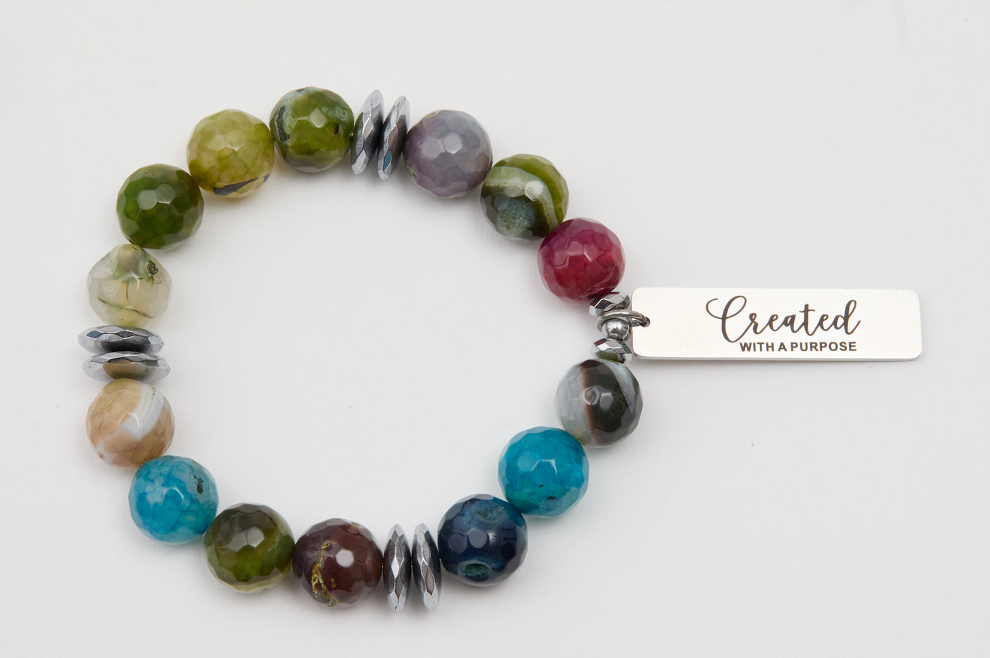 Multicolored beaded bracelet with a silver tag on a white background