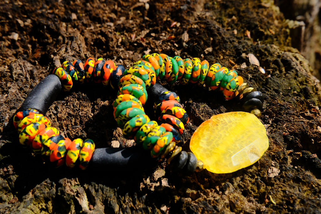 Colorful beaded bracelets on a textured surface