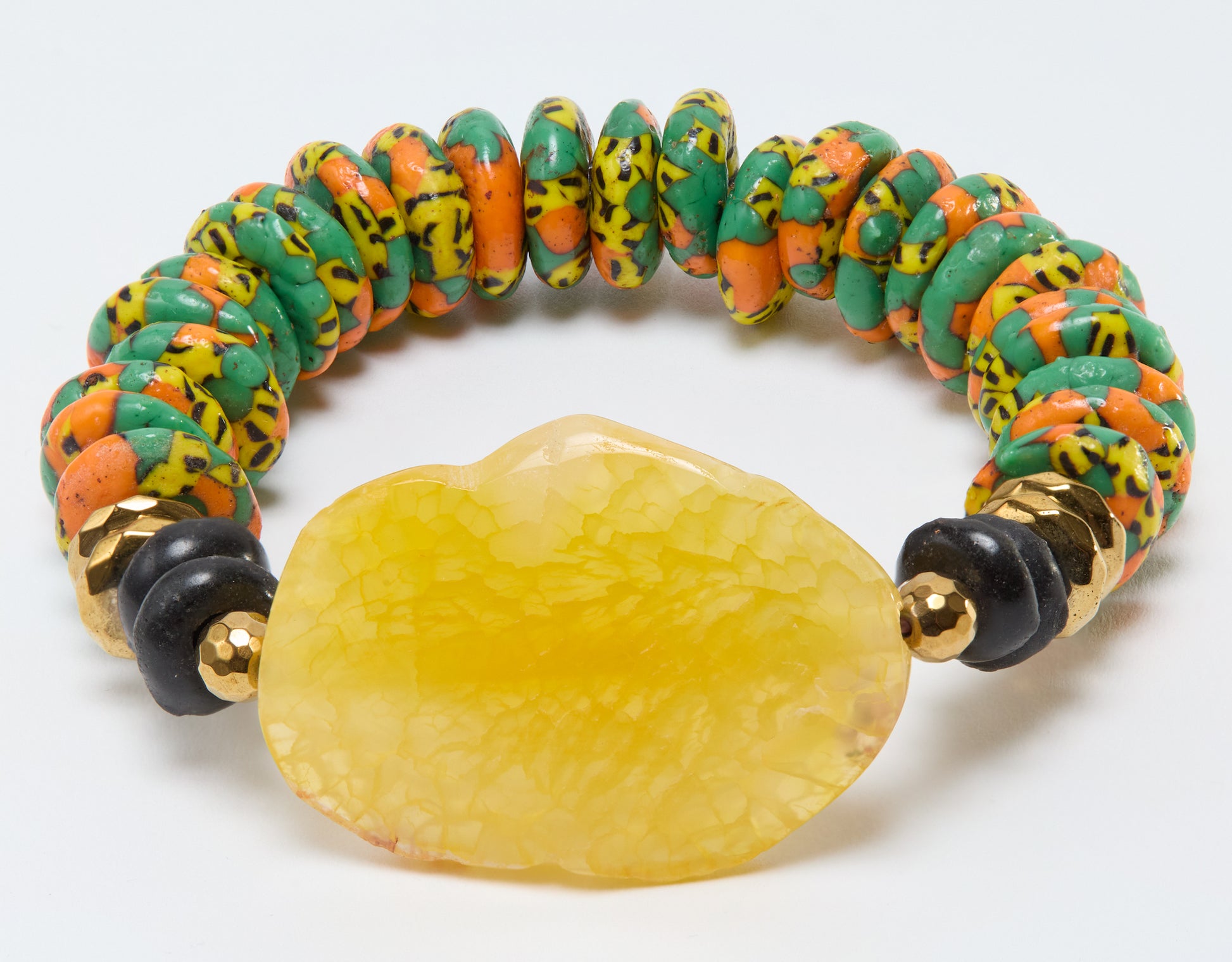 Colorful beaded bracelet with a large yellow stone on a white background