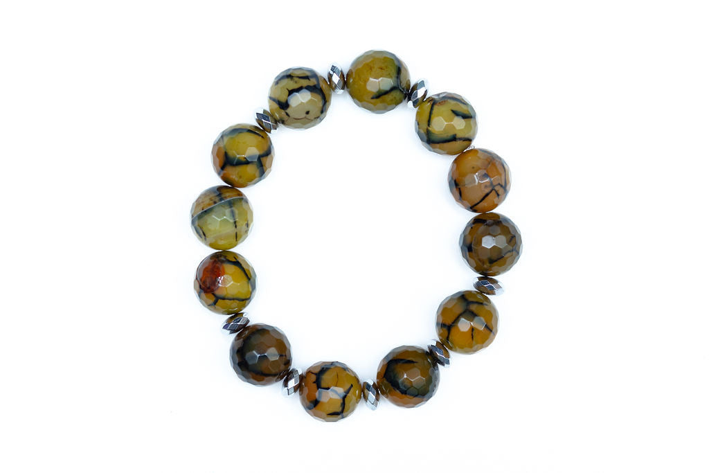 A bead bracelet with a combination of brown, black, and green faceted beads with hematite accents, against a white background. 