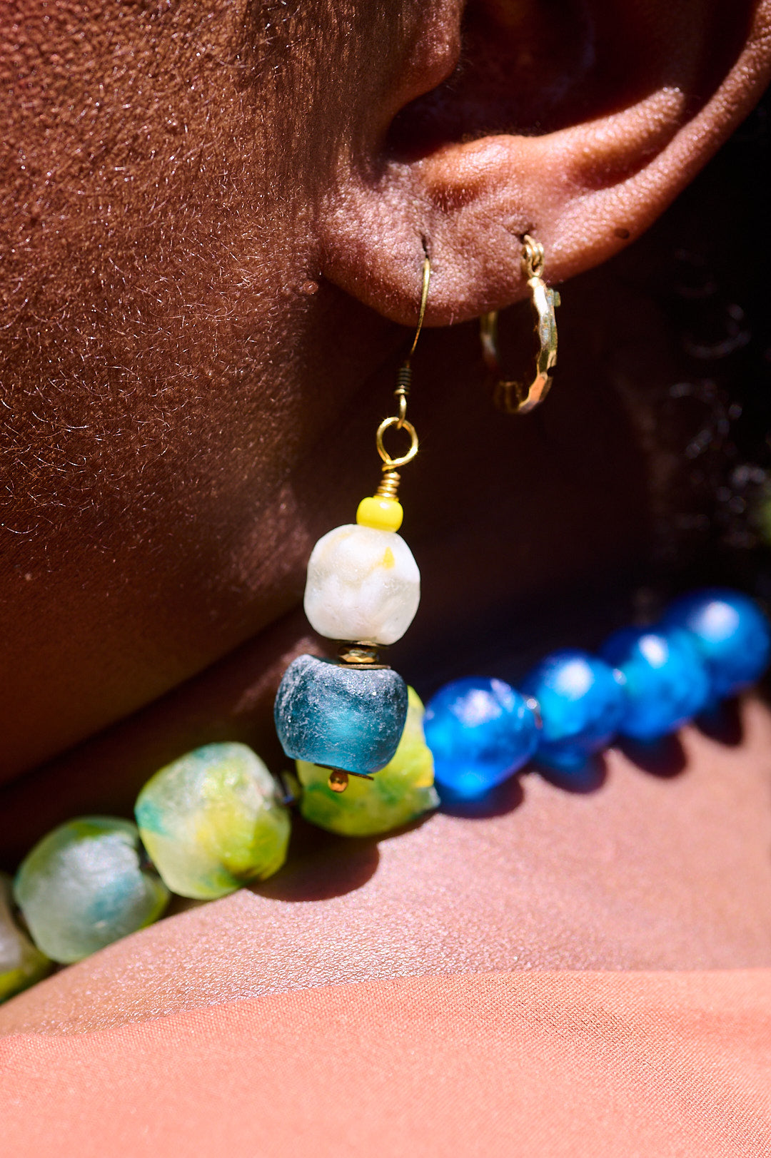 Close up of blue, white, and yellow African recycled glass bead drop earring with Semira necklace.