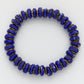 Blue beaded bracelet with gold accents on a white background