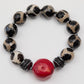 Beaded bracelet with black, white, and red beads on a white background