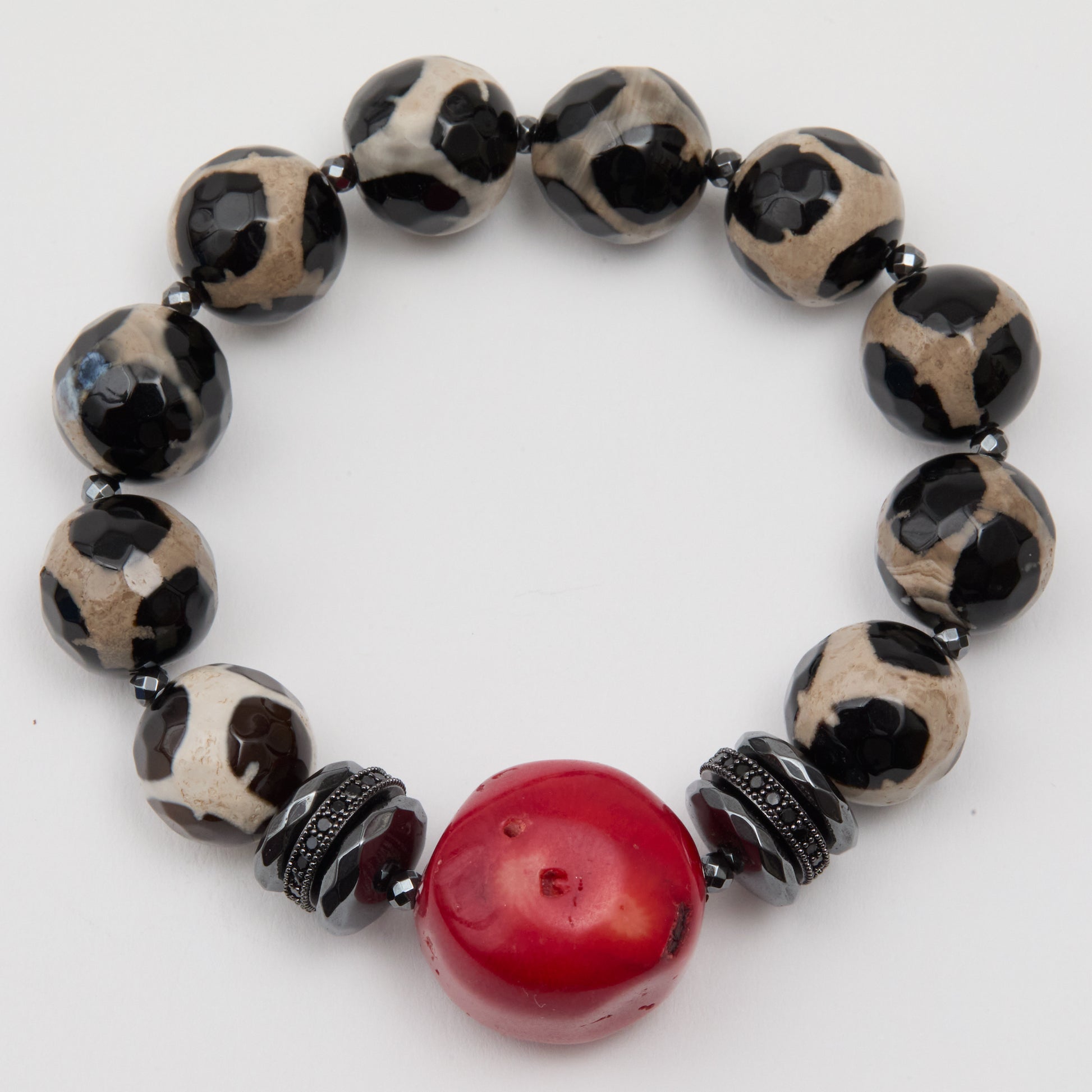 Beaded bracelet with black, white, and red beads on a white background