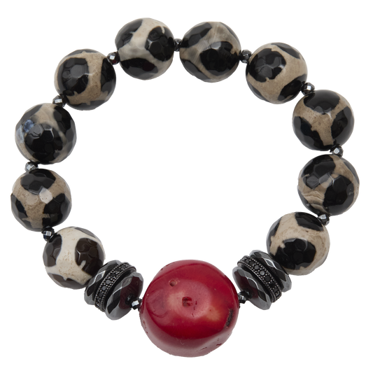 Bracelet with black and white patterned beads and a red central bead on a white background