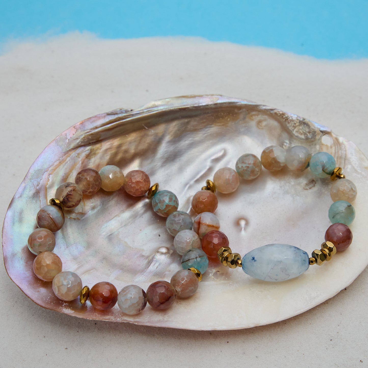 Multicolored beaded bracelet on a large shell with a blue background