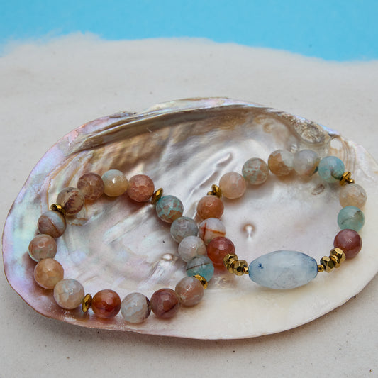 Multicolored beaded bracelet on a large shell with a blue background