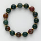Beaded bracelet with green and brown stones on a white background