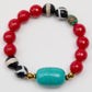 Beaded bracelet with red, black, white, and turquoise beads on a white background